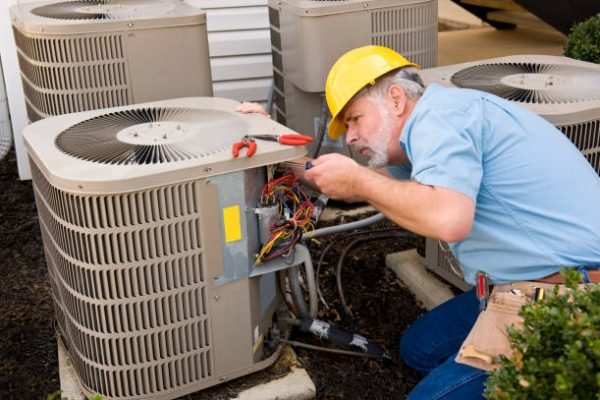 Technician inspecting a malfunctioning AC unit